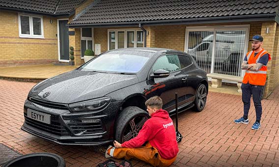 A man fitting a tyre onto a vehicle
